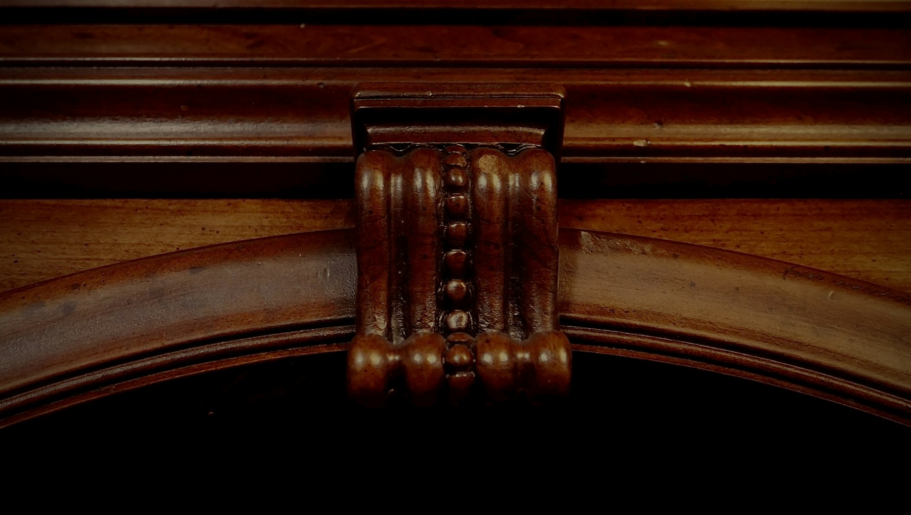 Détail sculpté d’un meuble en bois sombre